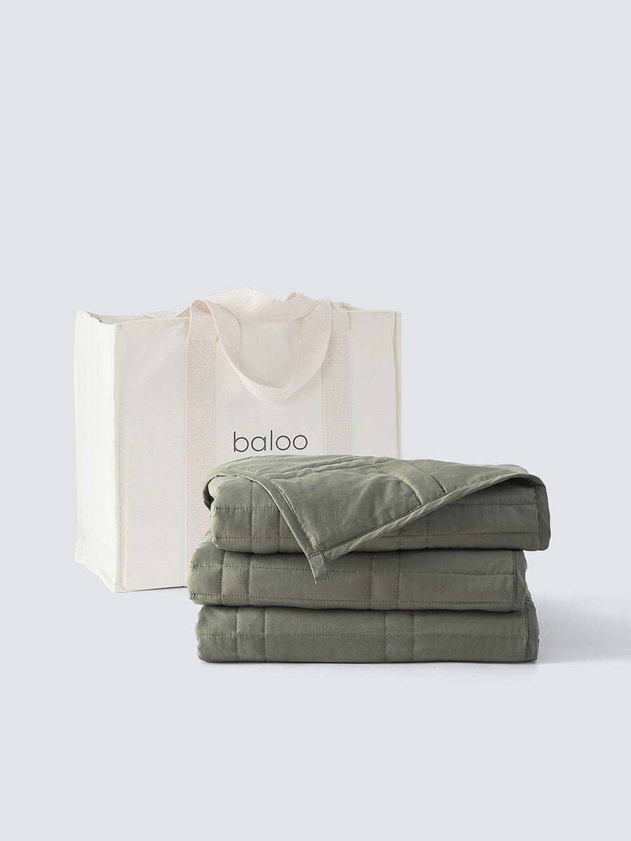 Folded weighted blanket in front of a white canvas tote [47867971961051, 47867972124891, 47867972223195, 47867972321499, 47880476590299, 47880476754139, 47880476852443, 47880476950747, 48114609160411, 48114590843099]