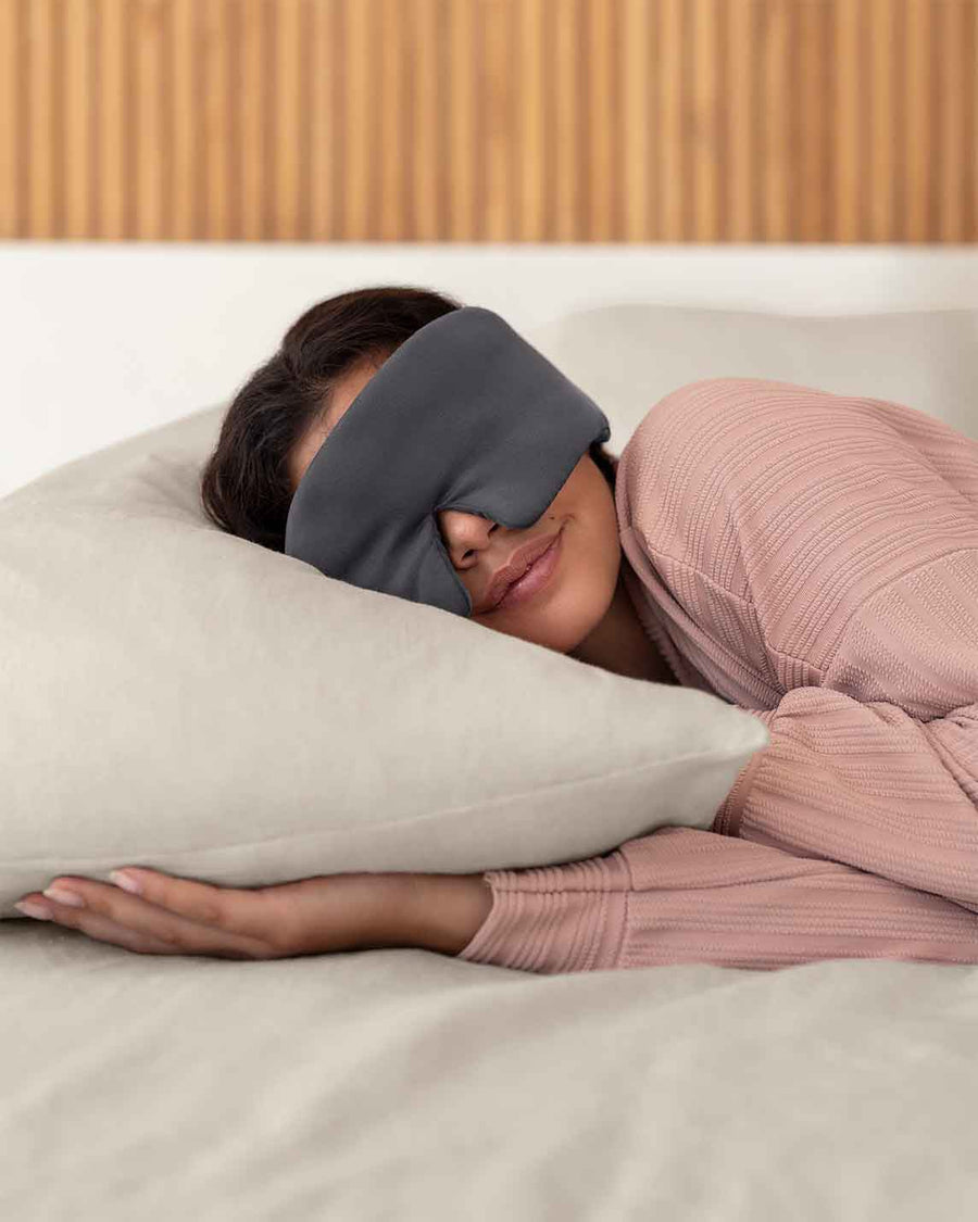 A woman with brown hair asleep on a pillow wearing a grey silk sleep mask [44377020793051,46730820911323, 46730820976859, 46730821042395, 46730821107931, 47185819435227]